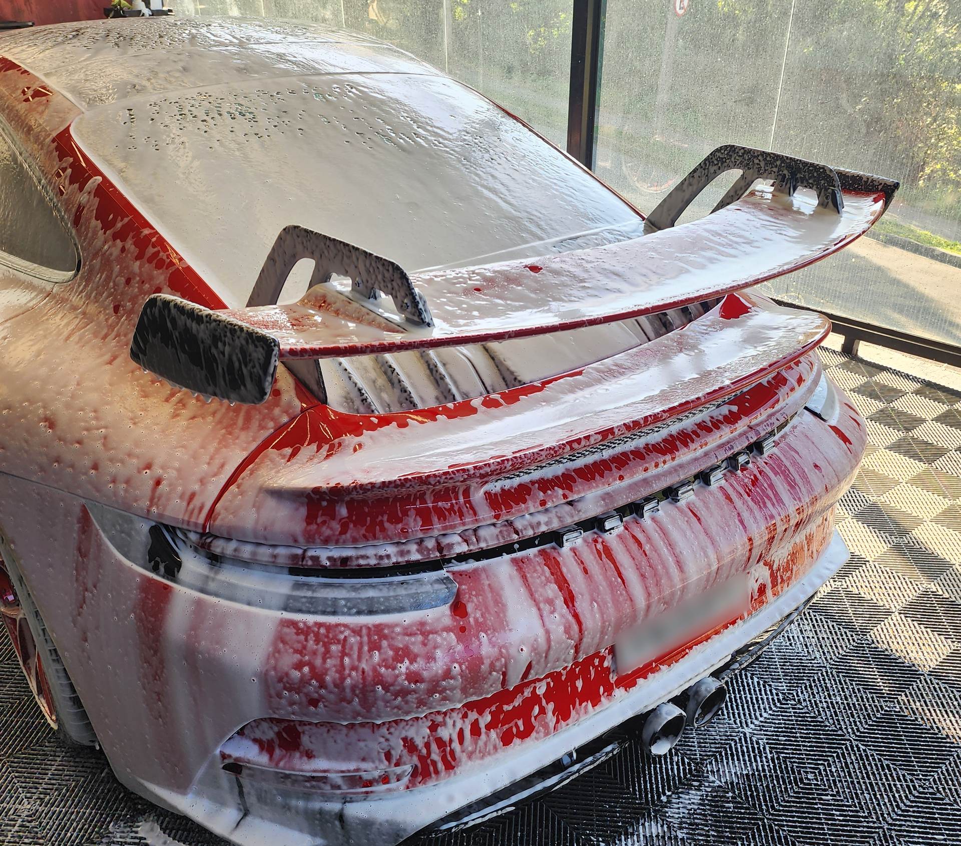 Traseira de um Porsche 911 GT3 vermelho coberta de espuma na pré-lavagem da Restauros Car Detail, em Sorocaba